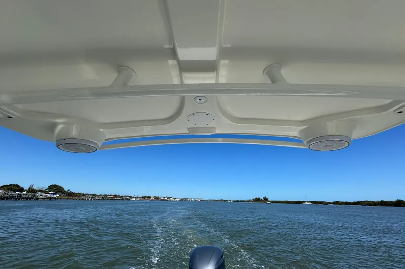 Slide: The Image of Edgewater 245CX Crossover boat cruising on a sunny day, view from under the canopy. - 25