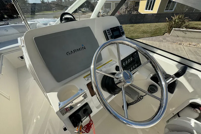 Slide: The Image of Edgewater 245CX Crossover 2012 boat helm with Garmin navigation system and steering wheel. - 4