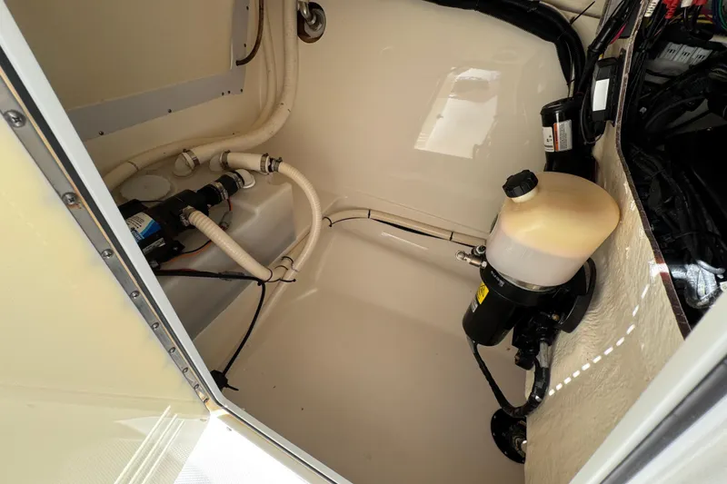 Slide: The Image of Interior view of 2012 Edgewater 245CX Crossover boat's engine compartment with hoses and components. - 7