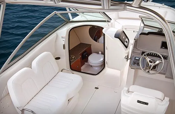 Slide: The Image of Manufacturer Provided Image: 2013 Robalo R247 Dual Console boat interior with seating and marine toilet. - 10