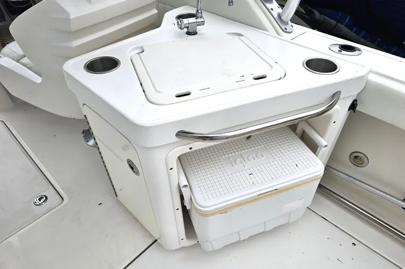 Slide: The Image of 2013 Robalo R247 Dual Console boat interior with sink and Igloo cooler storage. - 19