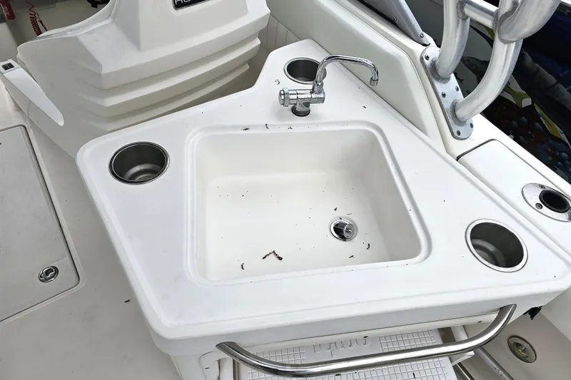 Slide: The Image of 2013 Robalo R247 Dual Console boat sink with faucet and cup holders. - 20