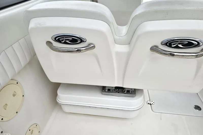 Slide: The Image of 2013 Robalo R247 Dual Console boat interior with seating and storage compartment. - 22