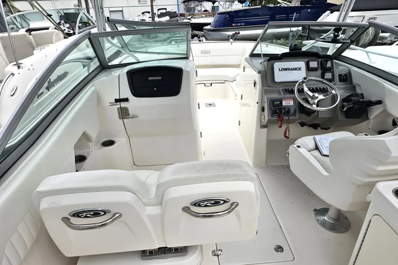 Slide: The Image of 2013 Robalo R247 Dual Console boat interior with steering wheel and seating. - 23