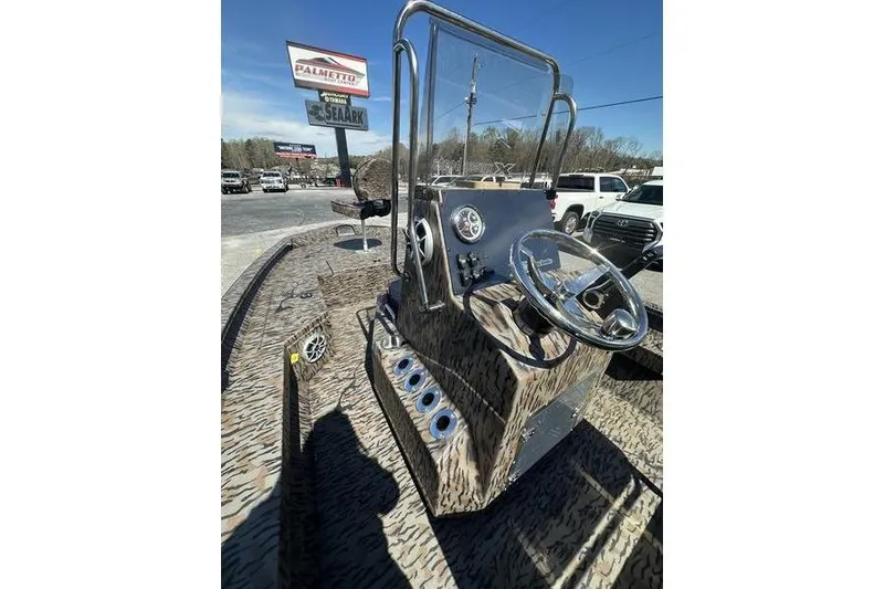 Slide: The Image of 2026 Xpress H20B Bay boat console with steering wheel and controls, parked outdoors. - 11