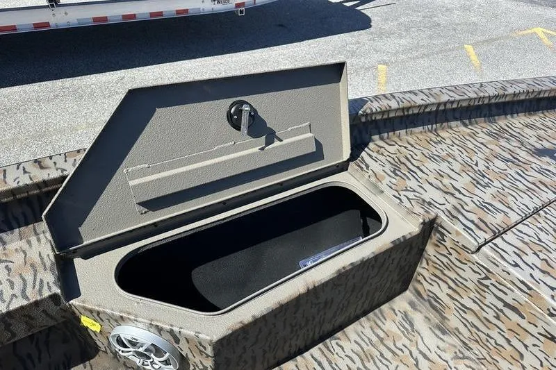 Slide: The Image of Open storage compartment on 2026 Xpress H20B Bay boat with camo pattern. - 12
