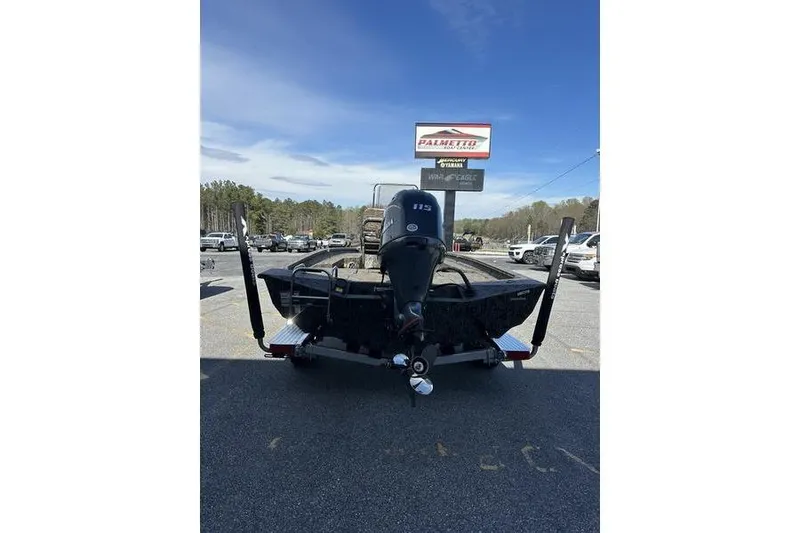 Slide: The Image of Rear view of 2026 Xpress H20B Bay boat with outboard motor in parking lot. - 2