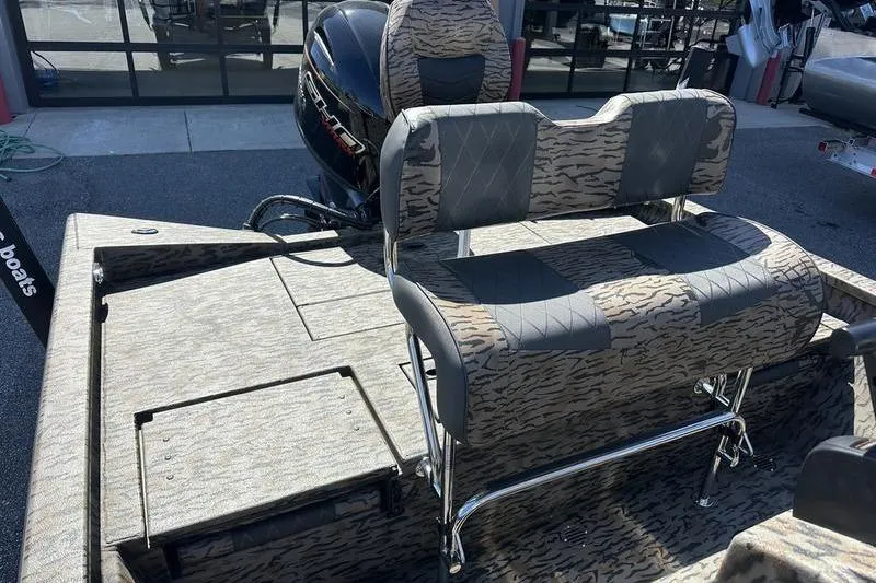 Slide: The Image of 2026 Xpress H20B Bay boat interior with patterned seating and motor. - 4