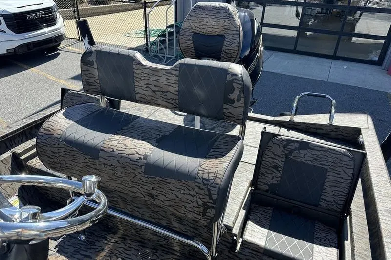 Slide: The Image of 2026 Xpress H20B Bay boat interior with camo-patterned seating and steering wheel. - 6