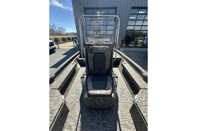 Slide: The Image of 2026 Xpress H20B Bay boat with camouflage seating, parked outdoors. - 8