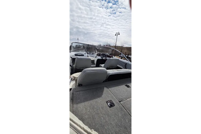 Slide: The Image of 2004 Triton SF-18 boat interior with seating and steering wheel under cloudy sky. - 5