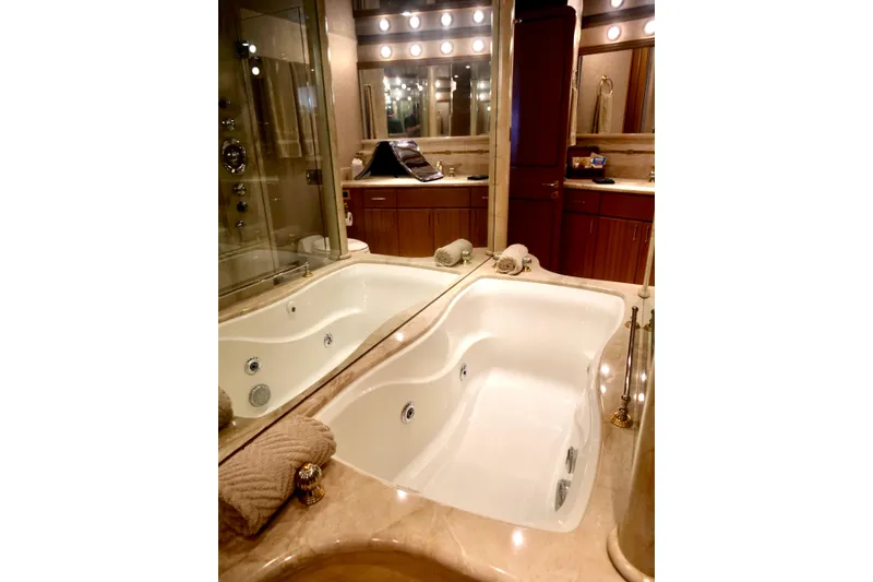 Slide: The Image of Luxurious bathroom with jacuzzi tub on 2000 Westport 112 yacht, featuring elegant lighting and wood cabinetry. - 21