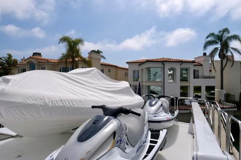 Slide: The Image of Luxury yacht Westport 112 with jet skis docked near waterfront homes, 2000 model. - 31