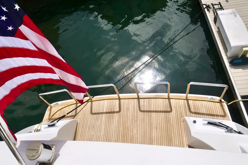 Slide: The Image of American flag on Westport 112 yacht deck, reflecting sunlight on water. - 32