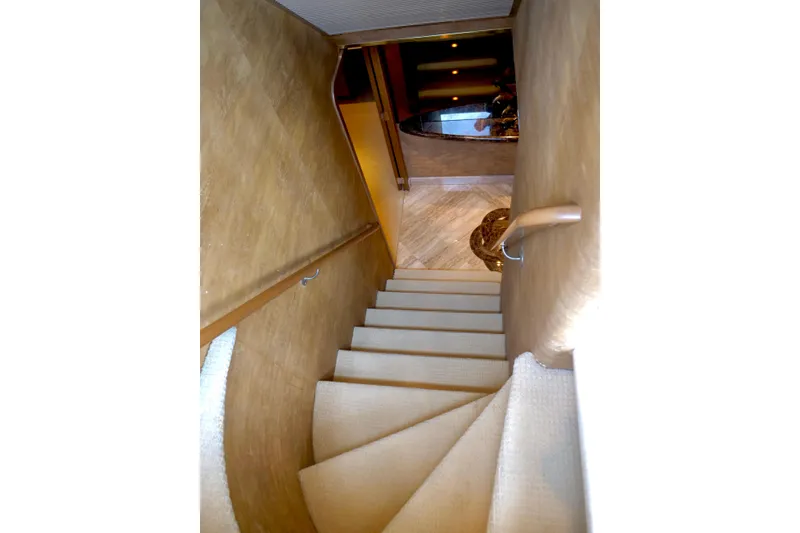 Slide: The Image of Staircase inside 2000 Westport 112 yacht, featuring elegant design and carpeting. - 8