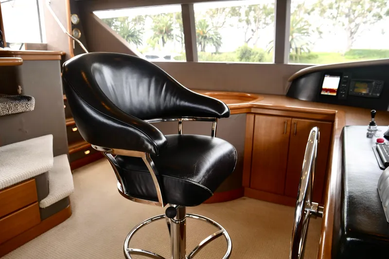 Slide: The Image of Luxurious helm chair in Westport 112 yacht interior, featuring sleek black leather and polished metal. - 93