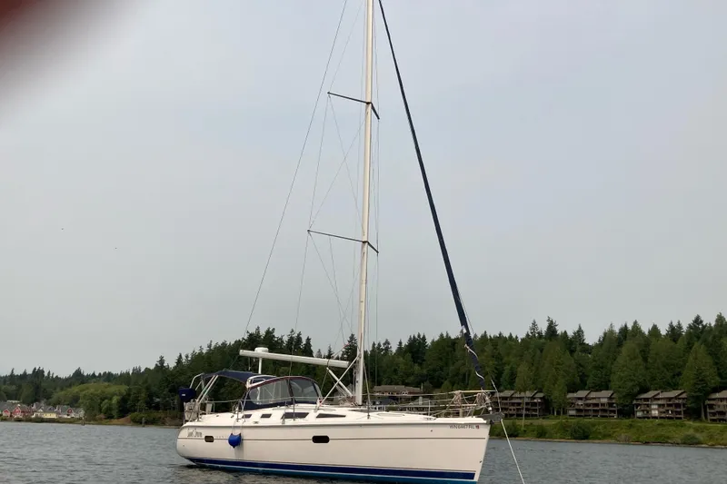 The Image of Sailboat on calm water, 2003 Hunter 356 model, with forested shoreline in the background. - 0