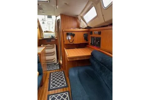 Slide: The Image of Interior of a 2003 Hunter 356 sailboat with wood finish and blue seating. - 11