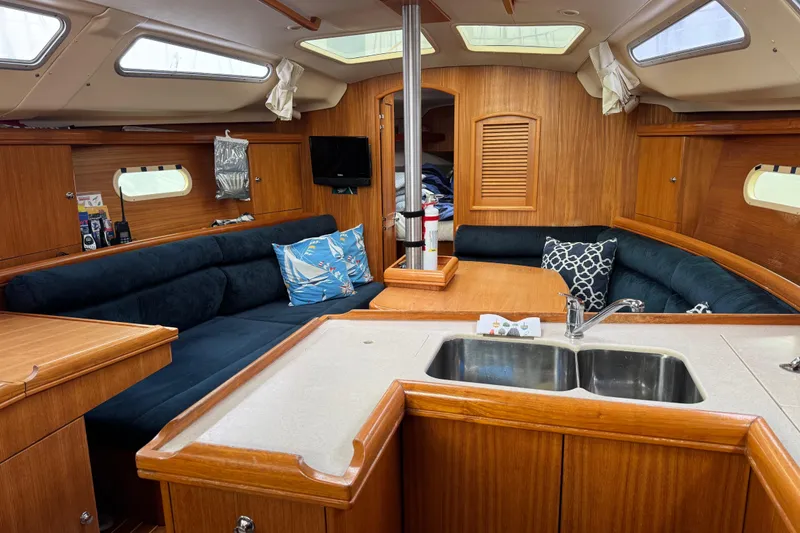 Slide: The Image of Interior of a 2003 Hunter 356 sailboat with cozy seating and wooden finishes. - 12