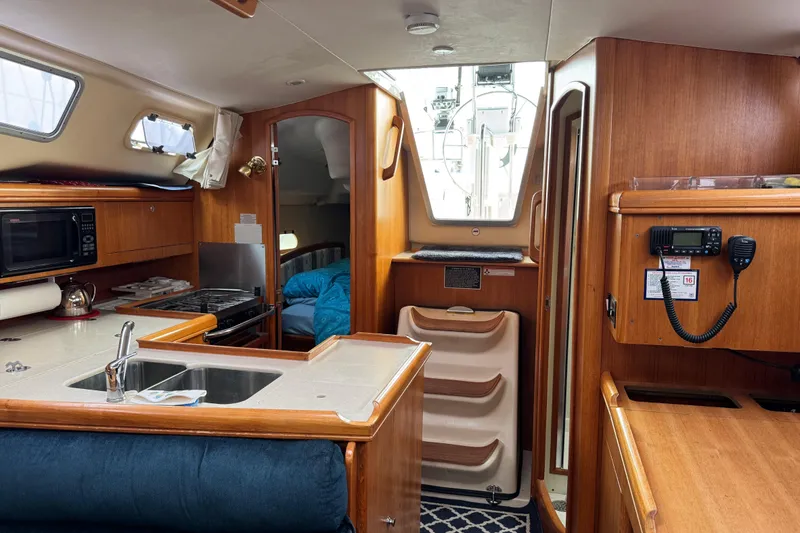 Slide: The Image of Interior of 2003 Hunter 356 sailboat with kitchen, sink, and navigation equipment. - 16