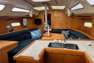 Slide: The Image of Interior of a 2003 Hunter 356 sailboat with wooden finishes and cozy seating. - 9