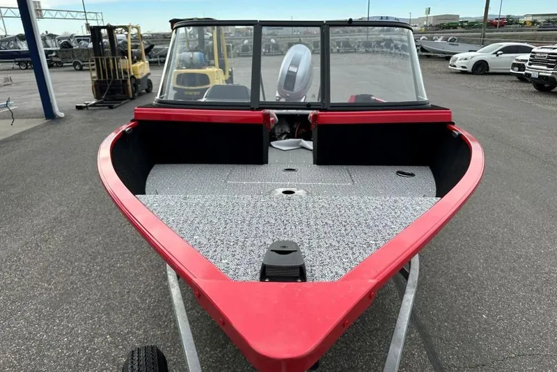 Slide: The Image of 2026 Smoker Craft Lazer 162 boat with red trim, parked outdoors. - 5