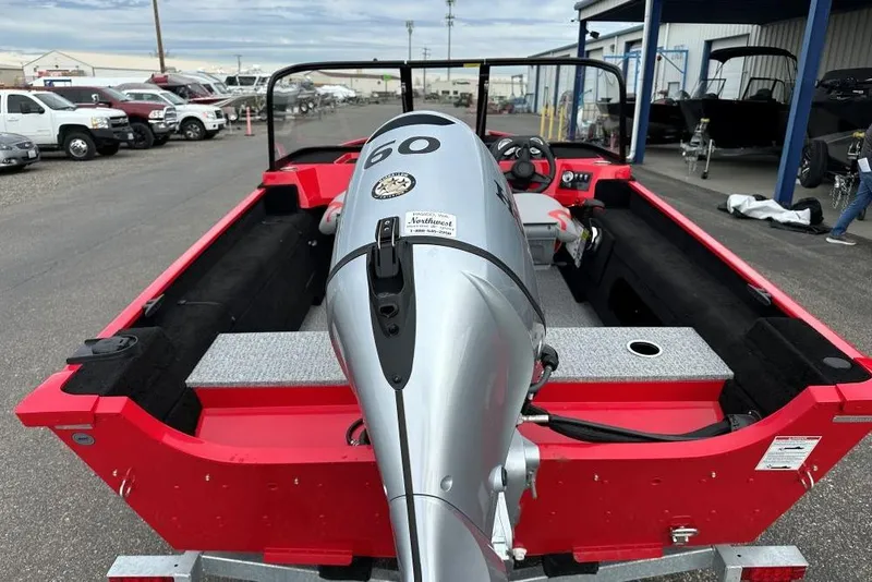 Slide: The Image of Red 2026 Smoker Craft Lazer 162 boat with a 60 HP outboard motor, parked outdoors. - 6