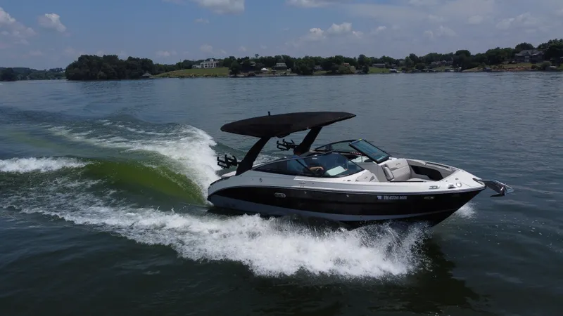 Slide: The Image of 2023 Sea Ray SLX 260 Surf boat cruising on a lake under a clear sky. - 16