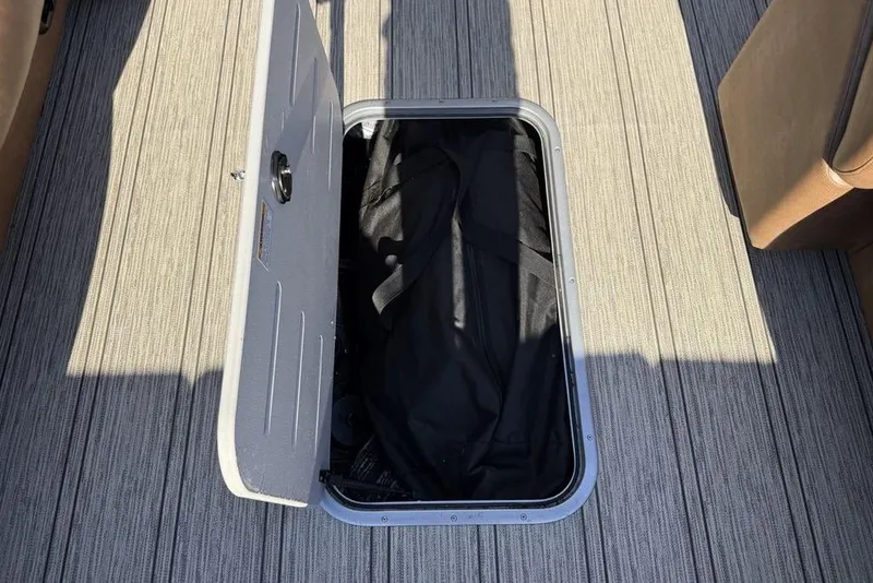 Slide: The Image of Open storage compartment on 2026 Premier 330 Escalante boat with carpeted flooring. - 25