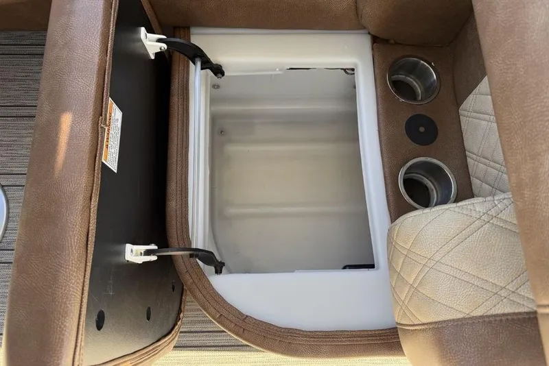 Slide: The Image of Interior storage compartment of 2026 Premier 330 Escalante with cup holders and brown upholstery. - 49