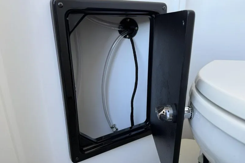 Slide: The Image of Open compartment with tubing next to a toilet in a 2026 Premier 330 Escalante. - 60