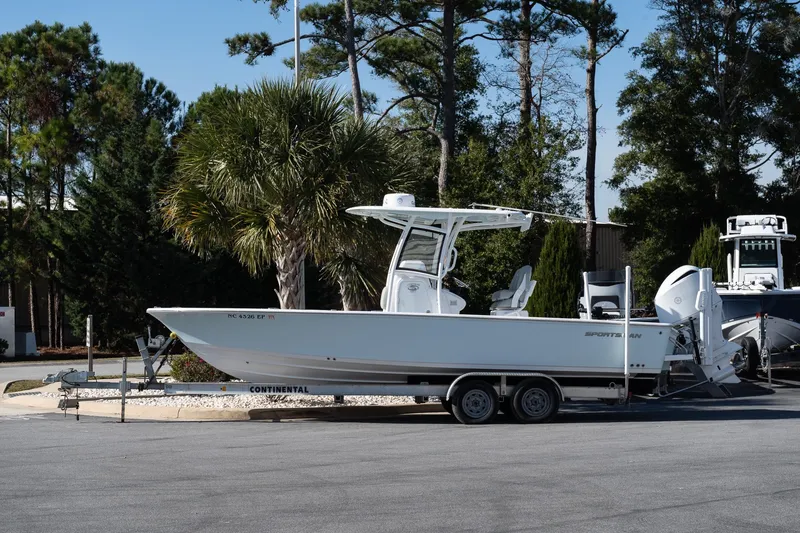 The Image of 2020 Sportsman Masters 267 Bay Boat on trailer, parked near trees. - 1