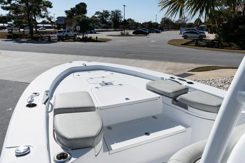 Slide: The Image of 2020 Sportsman Masters 267 Bay Boat with cushioned seating, parked near a road. - 14