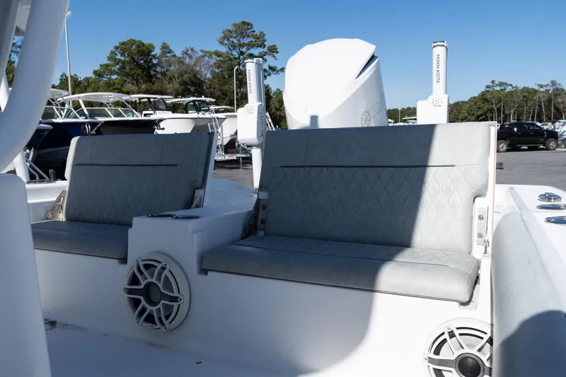 Slide: The Image of 2020 Sportsman Masters 267 Bay Boat interior seating with speakers, parked outdoors. - 8