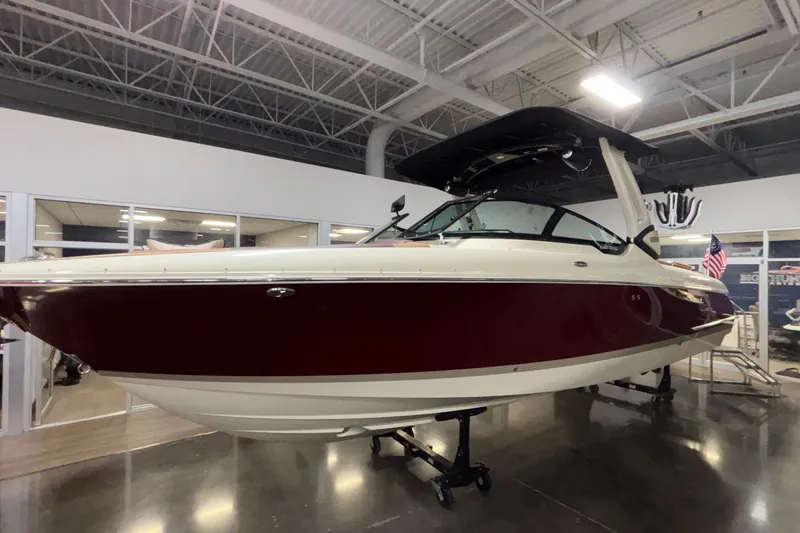 The Image of 2026 Chris-Craft Sportster 28 boat displayed indoors, featuring sleek design and maroon hull. - 0