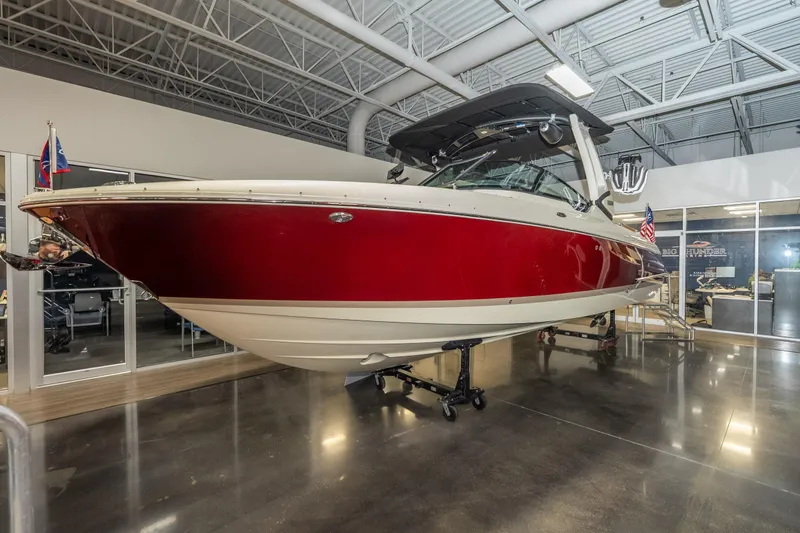 Slide: The Image of 2026 Chris-Craft Sportster 28 boat displayed indoors, featuring a sleek red and white design. - 12