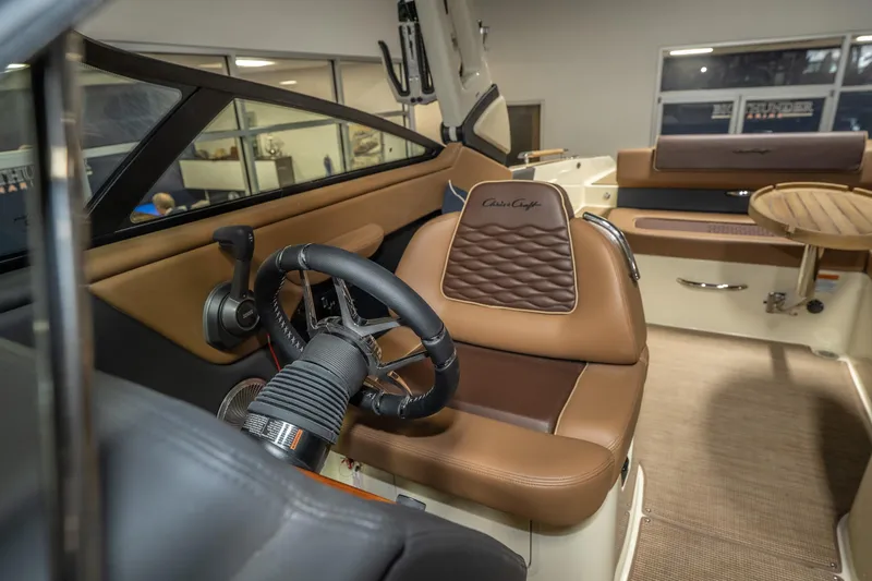 Slide: The Image of 2026 Chris-Craft Sportster 28 interior with luxurious leather seating and modern steering wheel. - 28