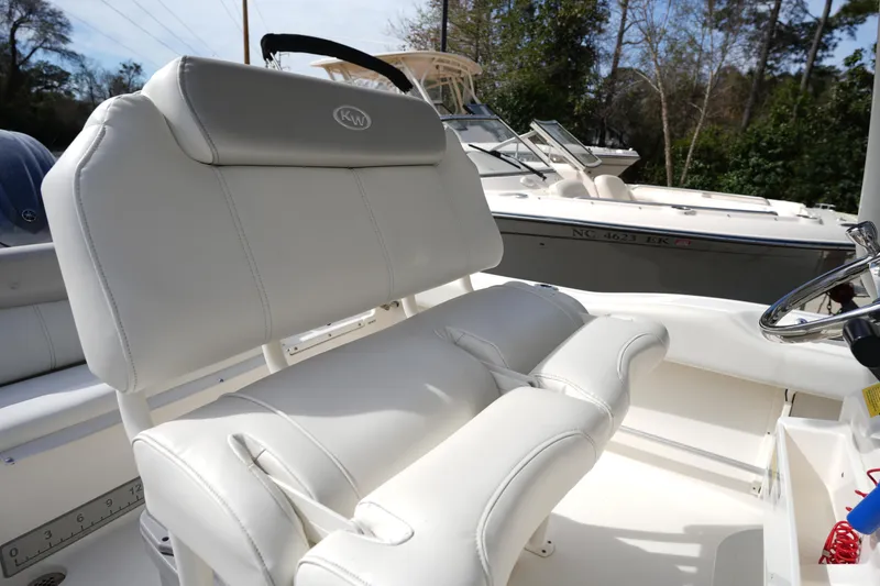 Slide: The Image of 2024 Key West 219 FS boat interior with white cushioned seating and steering wheel. - 11