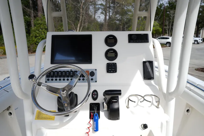 Slide: The Image of 2024 Key West 219 FS boat dashboard with steering wheel, controls, and display screens. - 14