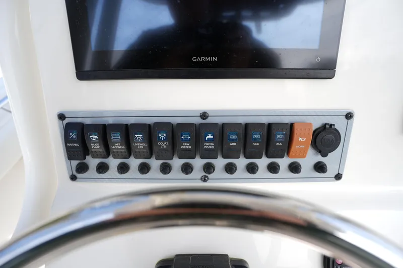 Slide: The Image of Control panel of 2024 Key West 219 FS boat with various switches and Garmin display. - 20