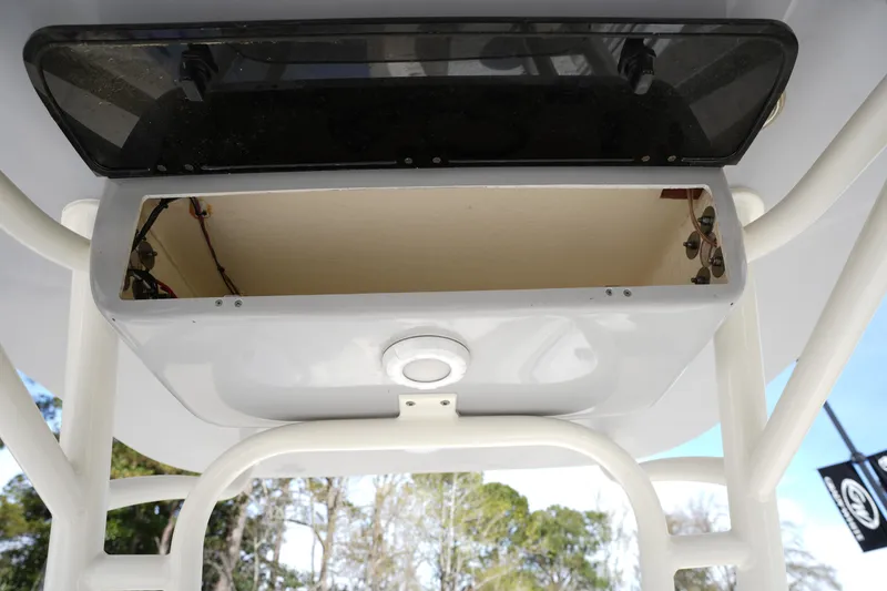 Slide: The Image of 2024 Key West 219 FS boat storage compartment with open lid and visible wiring. - 21