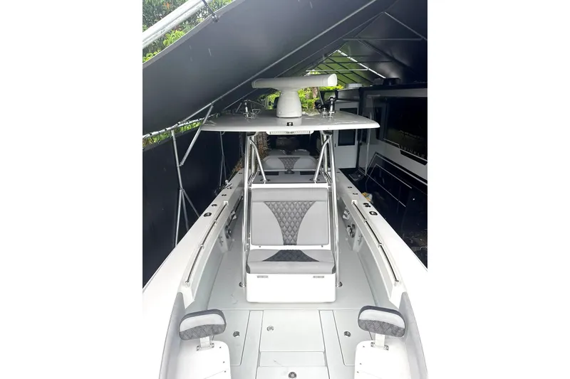 Slide: The Image of 2019 Contender 30 ST boat under shelter, showcasing sleek design and spacious deck. - 8