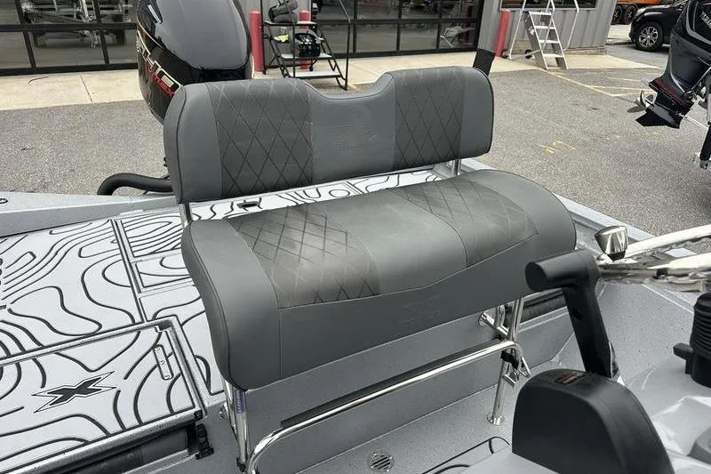Slide: The Image of 2025 Xpress H22B Bay boat with gray cushioned seating and modern design. - 10