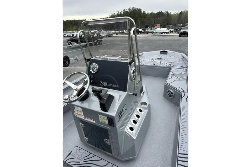 Slide: The Image of 2025 Xpress H22B Bay boat console with steering wheel and controls, parked outdoors. - 11