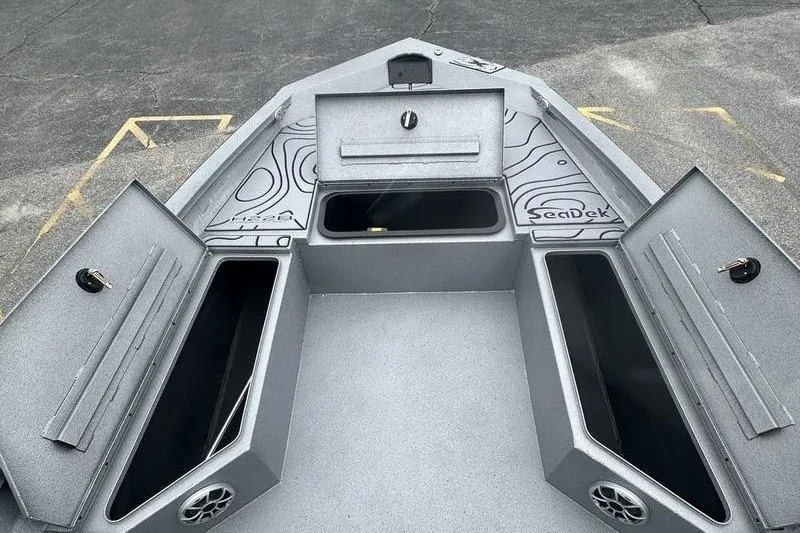 Slide: The Image of 2025 Xpress H22B Bay boat deck with open storage compartments and SeaDek flooring. - 17