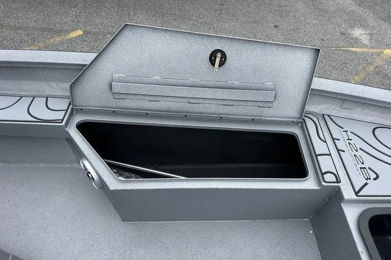 Slide: The Image of Open storage compartment on 2025 Xpress H22B Bay boat deck. - 18