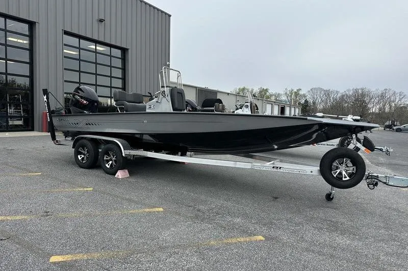 Slide: The Image of 2025 Xpress H22B Bay boat on trailer outside a warehouse. - 6