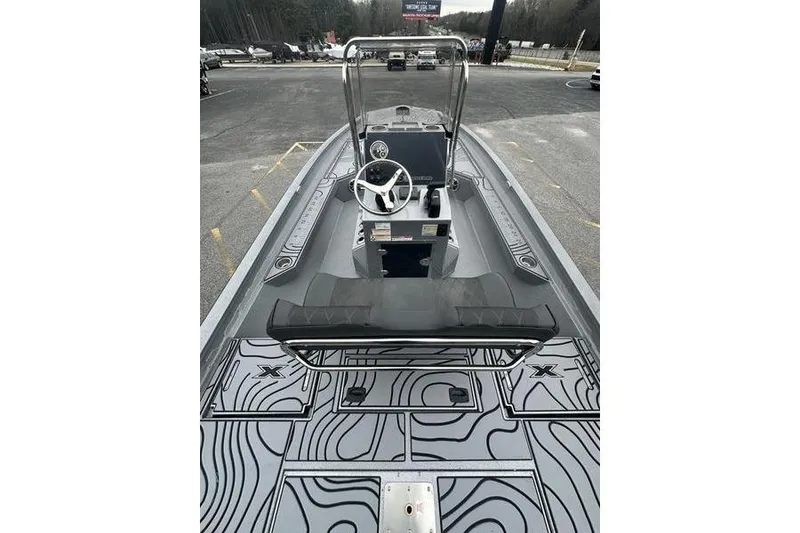 Slide: The Image of 2025 Xpress H22B Bay boat interior with steering console and patterned flooring. - 7