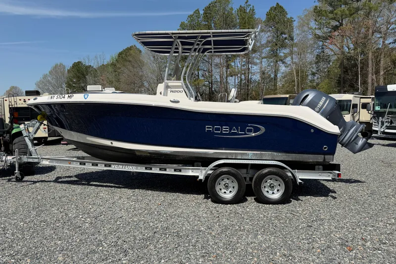 Slide: The Image of 2019 Robalo R200 Center Console boat on trailer, parked outdoors. - 16