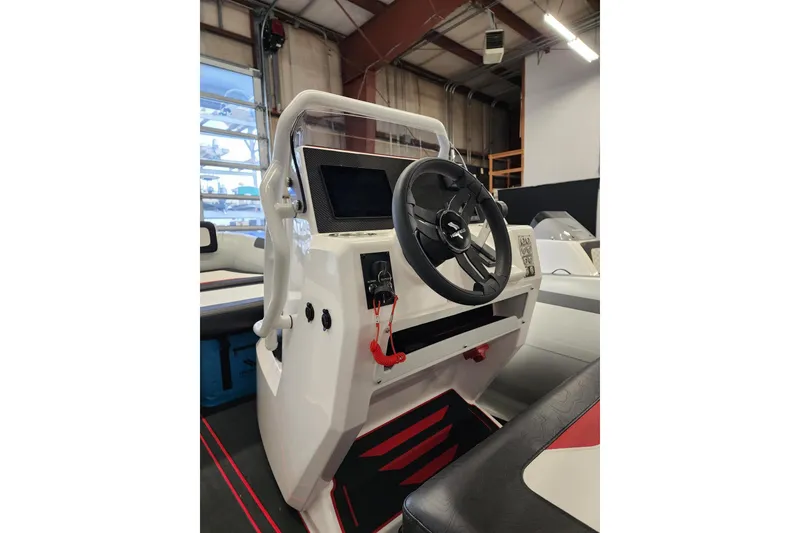 Slide: The Image of 2026 Highfield Velox 560 boat console with steering wheel and control panel in a showroom. - 12